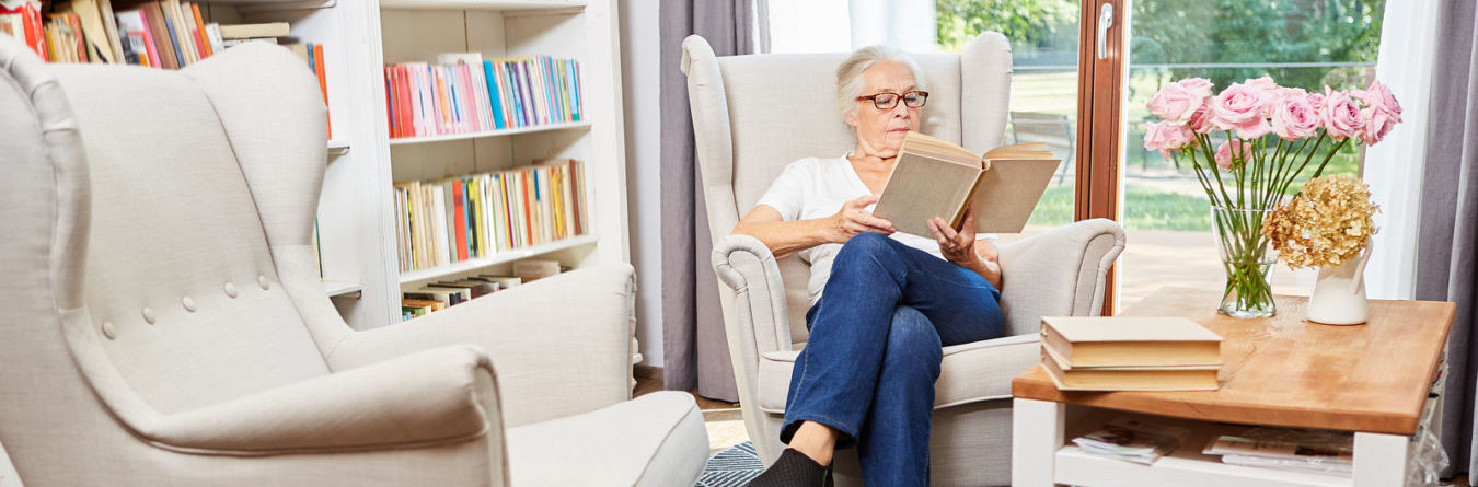 Elderly Woman sitting in chair reading