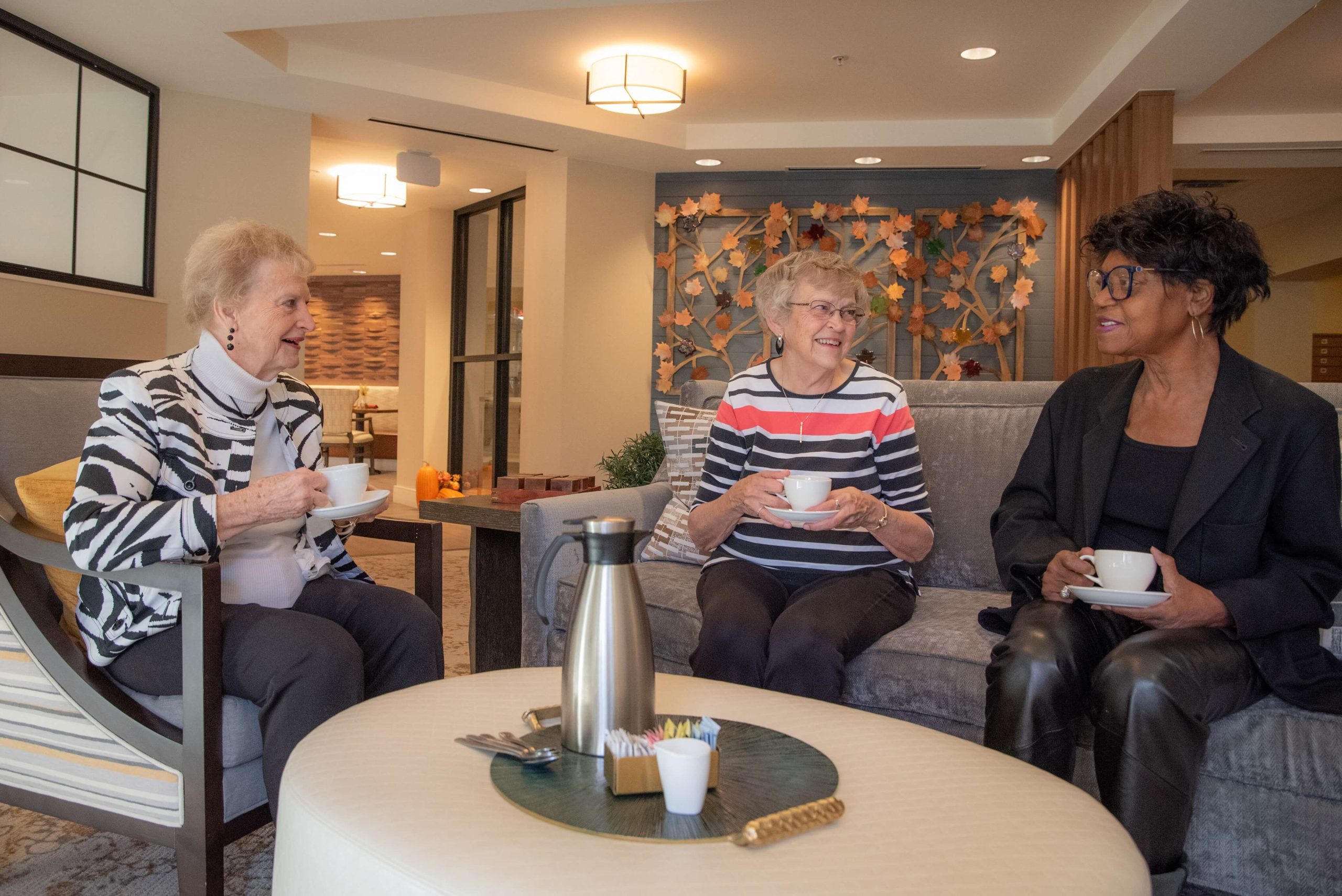 Clermont Park Senior Living Community in Denver, CO - clermont park residents enjoying coffee in newly renovated living room scaled 1