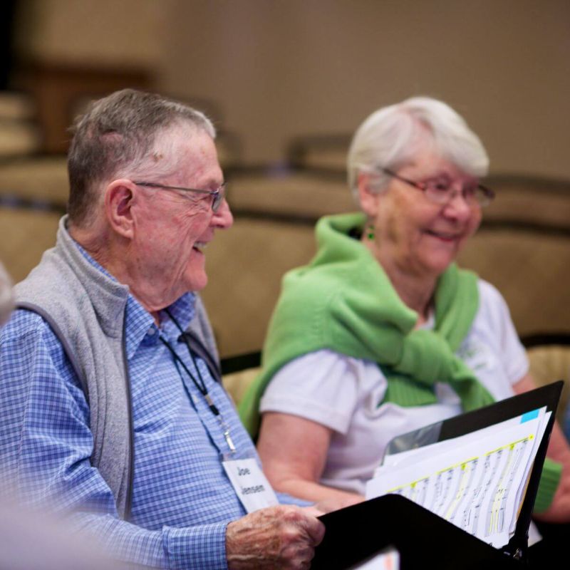 Clermont Park Senior Living Community in Denver, CO - older man and woman smiling at choir rehearsal square