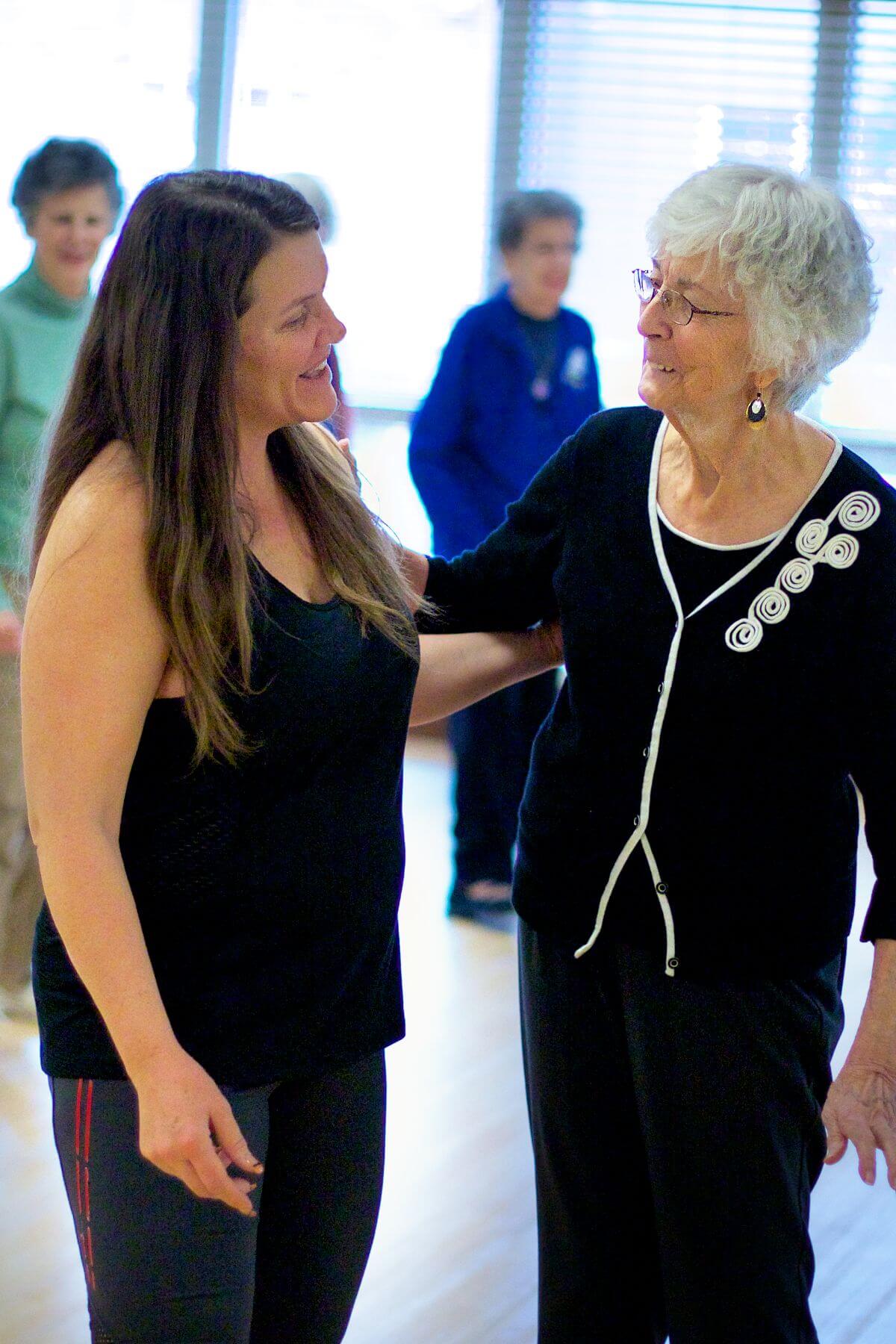 Clermont Park Senior Living Community in Denver, CO - older woman and life enrichment team member at dance class