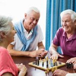 Clermont Park Senior Living Community in Denver, CO - group of older adults playing chess