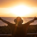 Clermont Park Senior Living Community in Denver, CO - rear,view,of,woman,silhouette,admiring,the,orange,sunset,over