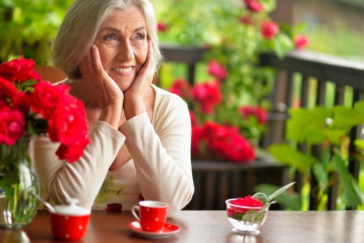 Clermont Park Senior Living Community in Denver, CO - older woman smiling and drinking tea