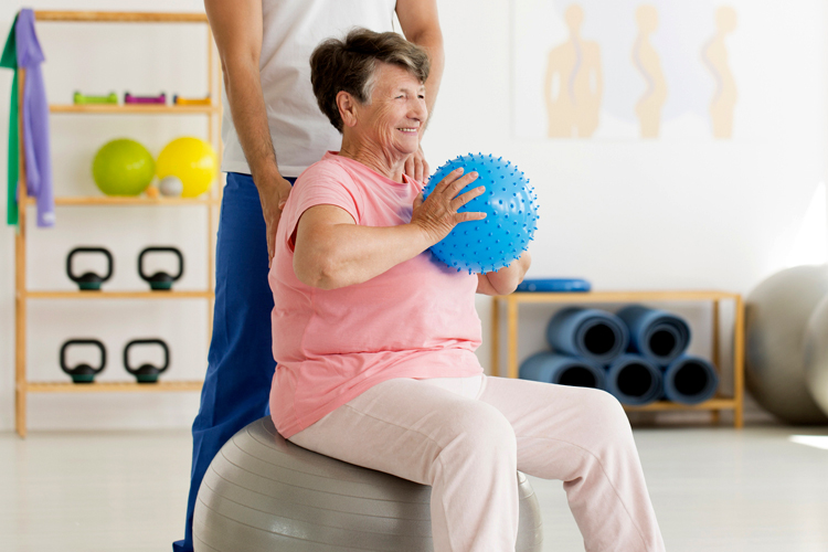 Clermont Park Senior Living Community in Denver, CO - senior woman exercising with ball