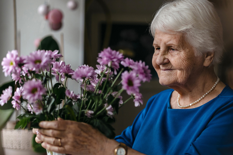 clermont park senior woman arranging flowers Clermont Park Senior Living Community in Denver, CO - clermont park senior woman arranging flowers