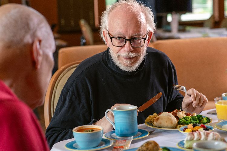 Clermont Park Senior Living Community in Denver, CO - residents talking over meal