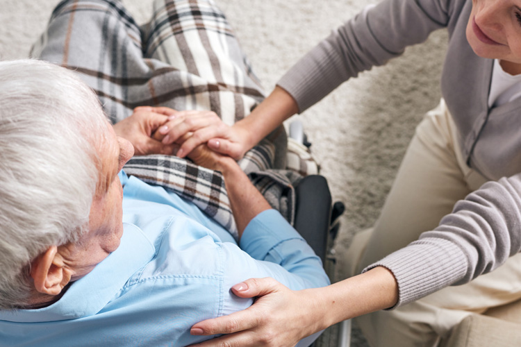 Clermont Park Senior Living Community in Denver, CO - clermont park senior man in wheelchair with female caregiver