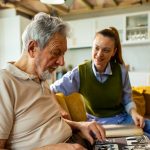 Clermont Park Senior Living Community in Denver, CO - clermont park senior man looking at photo album with daughter