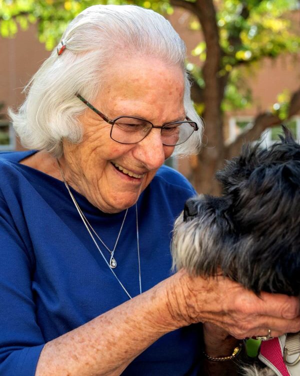 Clermont Park Senior Living Community in Denver, CO - older woman smiling at her dog